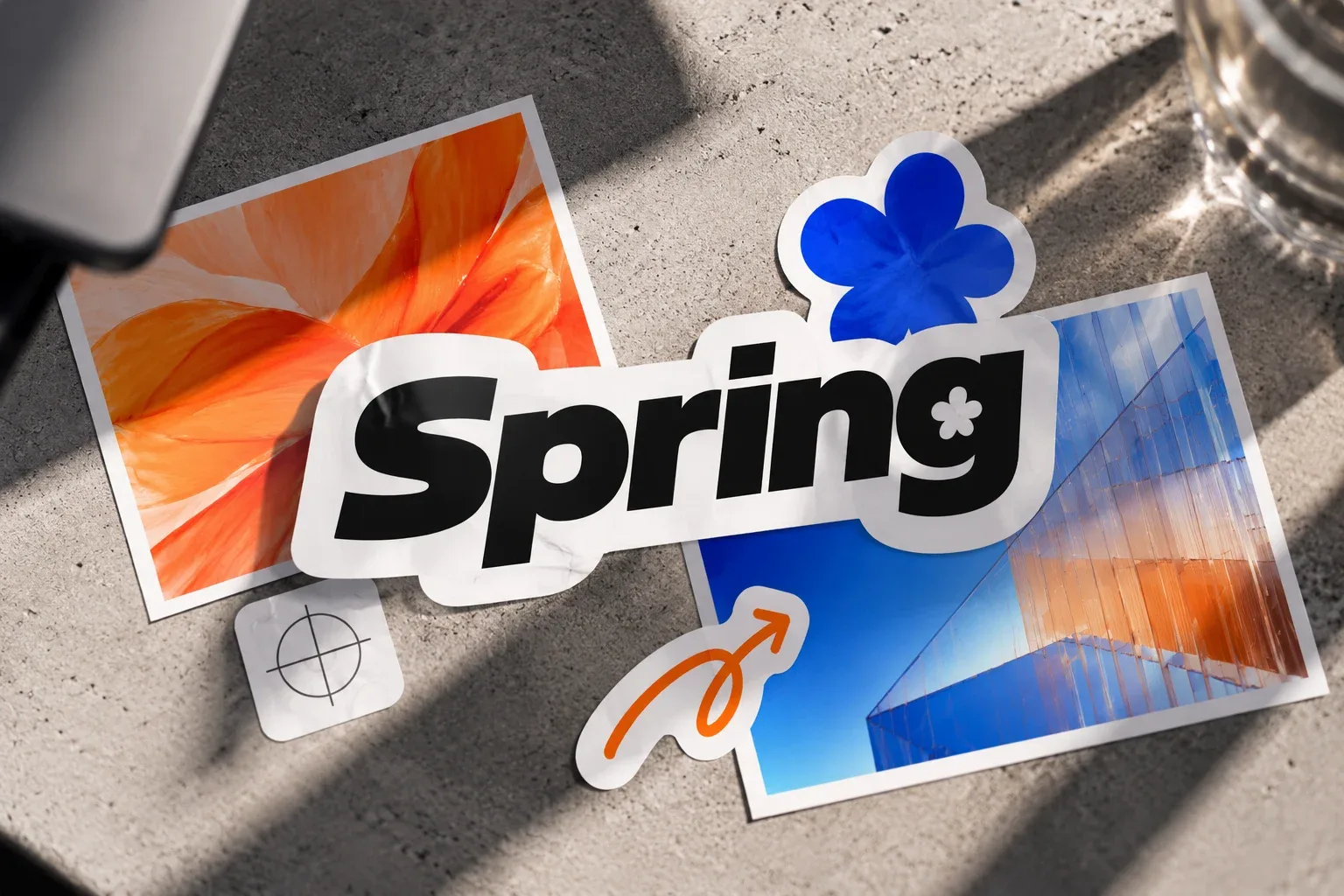 Collage de stickers de Spring sobre concreto: flor naranja, flor azul y arquitectura de cristal